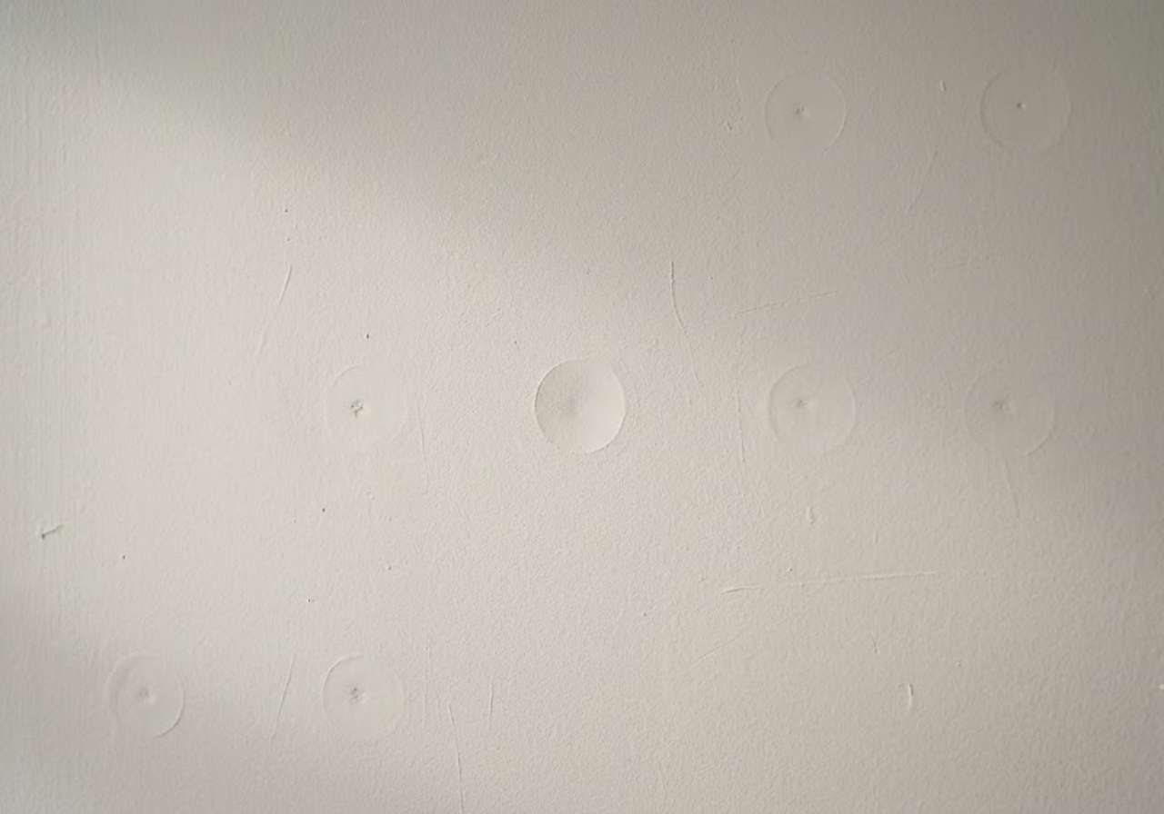 Neatly patched drill and fill holes on a Denver wall