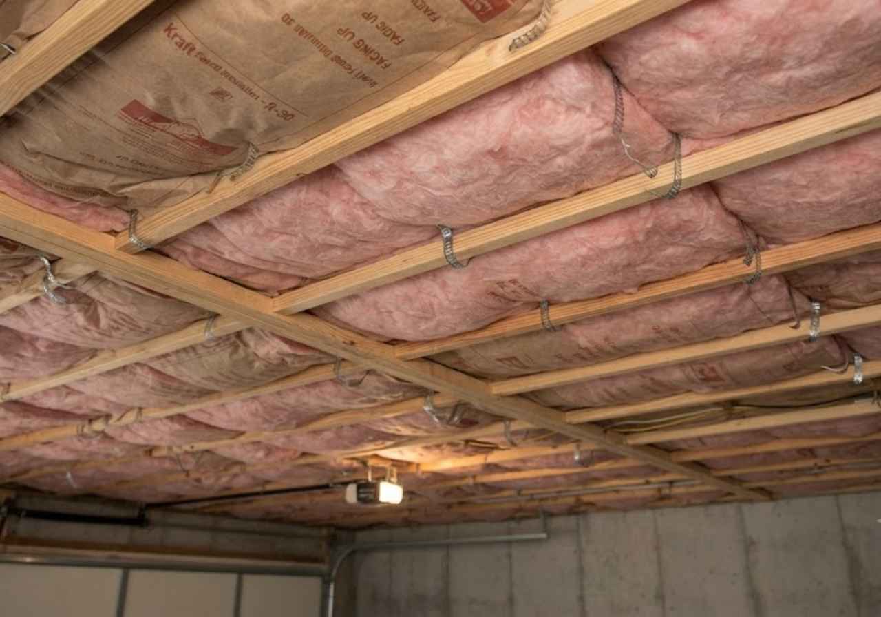 R19 floor batts held by wire supports above a Denver garage